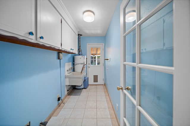 laundry area featuring sink and light tile patterned floors