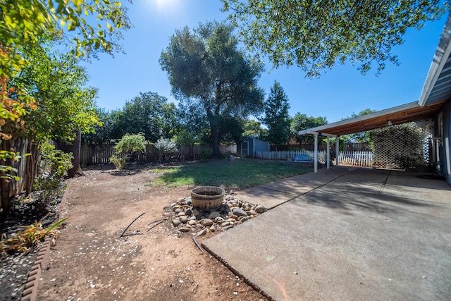 view of yard featuring a storage shed, a fire pit, and a patio area