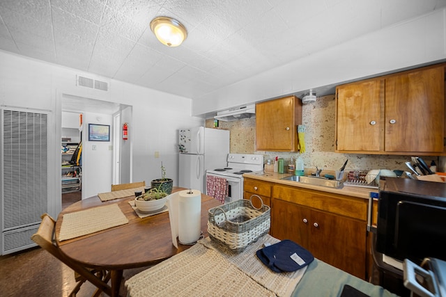 kitchen with range hood, white appliances, and sink