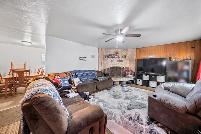 carpeted living room featuring ceiling fan, a textured ceiling, and a fireplace