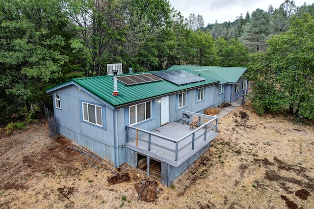 exterior space featuring central AC unit, solar panels, and a wooden deck