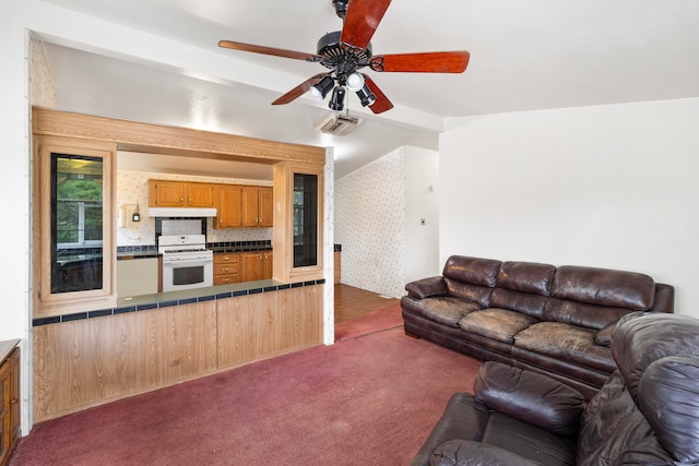 living room featuring ceiling fan and dark colored carpet