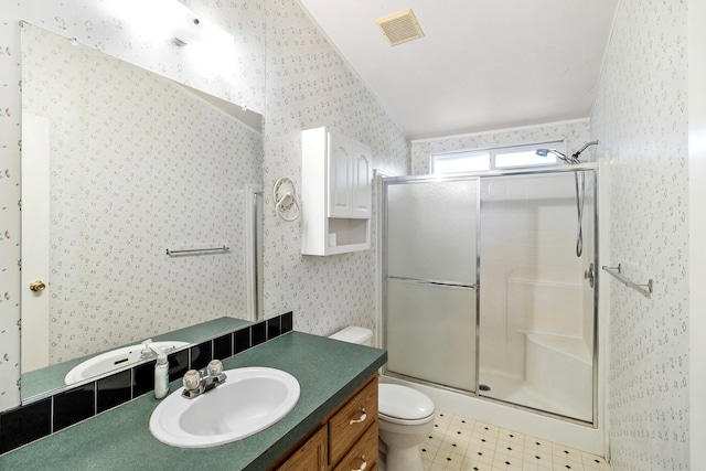 bathroom with lofted ceiling, walk in shower, vanity, and toilet