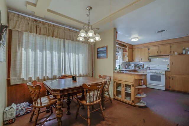 carpeted dining space featuring a notable chandelier