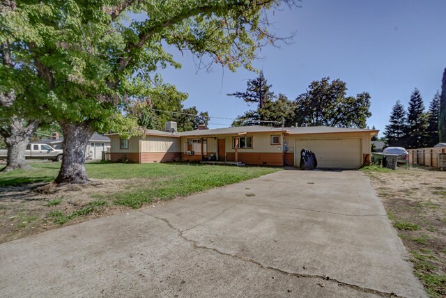 ranch-style house featuring a front yard and a garage