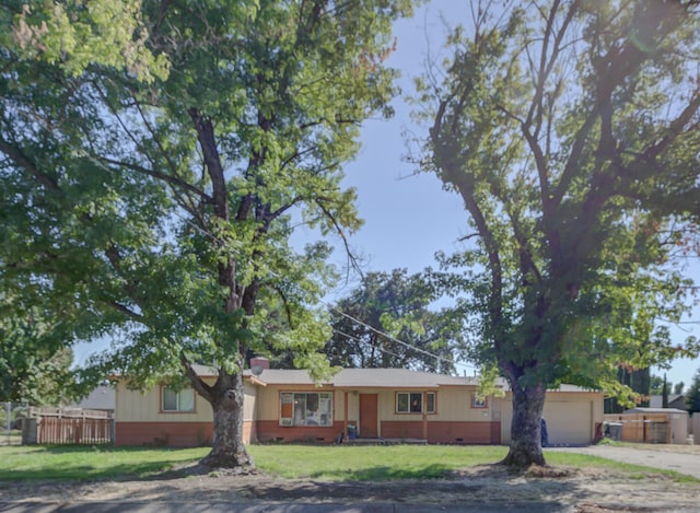 ranch-style home featuring a garage and a front lawn