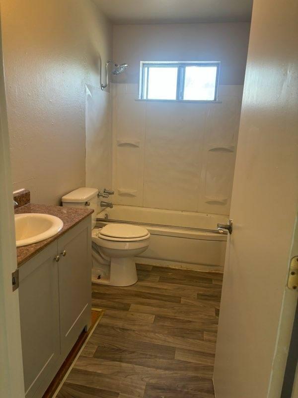 full bathroom featuring wood-type flooring, vanity, toilet, and bathtub / shower combination