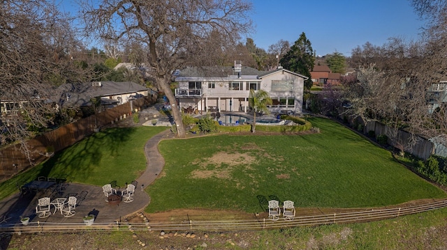 back of property with a fenced in pool, a yard, and a patio area