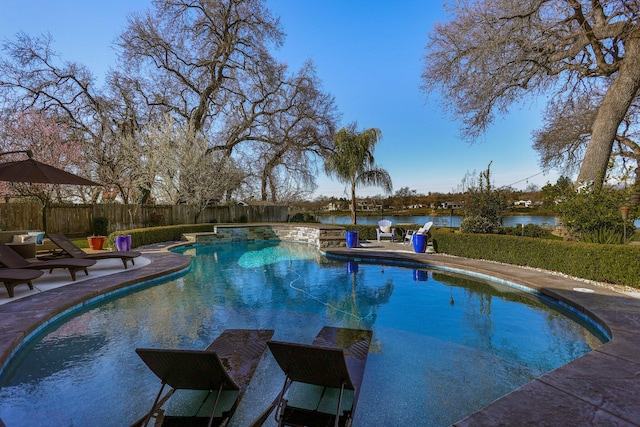 view of pool featuring a patio and a water view