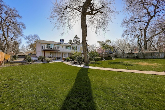 view of front of house with a balcony and a front lawn