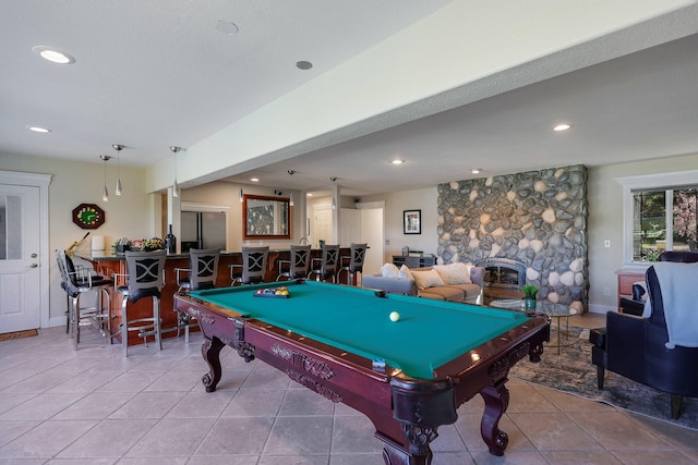 playroom featuring pool table, bar, a stone fireplace, and tile patterned flooring