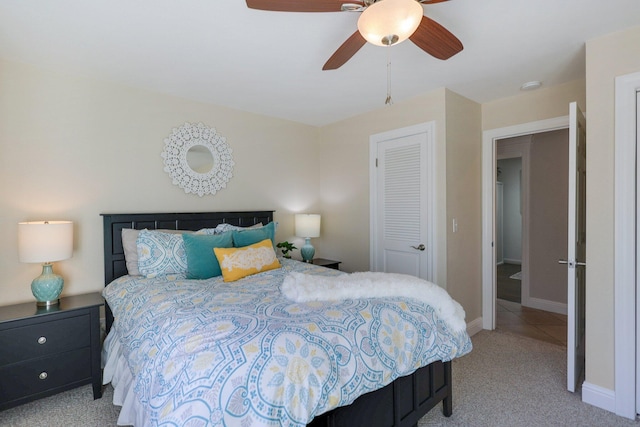 bedroom with ceiling fan, a closet, and light carpet