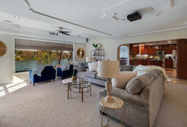 carpeted living room with ceiling fan