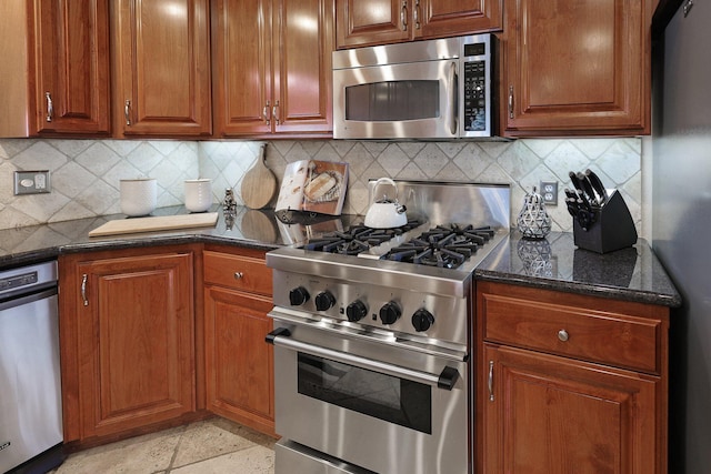 kitchen featuring decorative backsplash, stainless steel appliances, and dark stone countertops