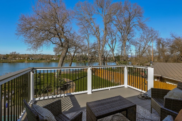 deck with a water view and a yard