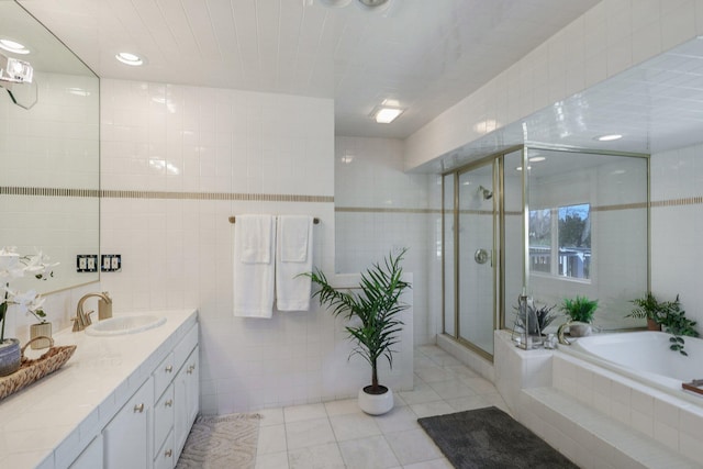 bathroom featuring tile walls, tile patterned floors, vanity, and separate shower and tub