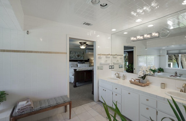 bathroom with ceiling fan, vanity, tile walls, and tile patterned flooring