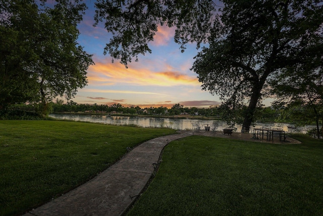 surrounding community featuring a lawn and a water view