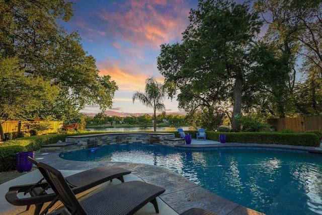 pool at dusk featuring a patio area