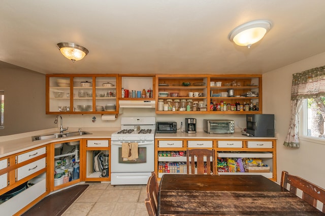 kitchen featuring light tile patterned floors, gas range gas stove, and sink