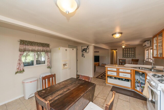 dining space featuring ceiling fan, sink, and a wall mounted AC