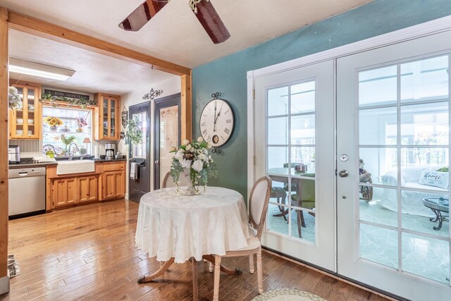 dining space featuring ceiling fan, light hardwood / wood-style floors, french doors, and sink