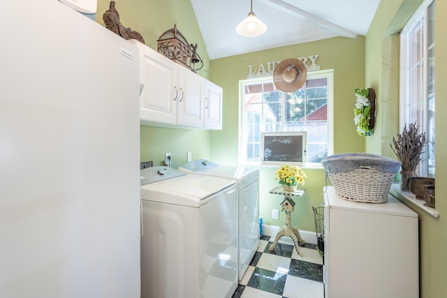 laundry area featuring tile patterned floors, washing machine and dryer, cabinet space, and baseboards