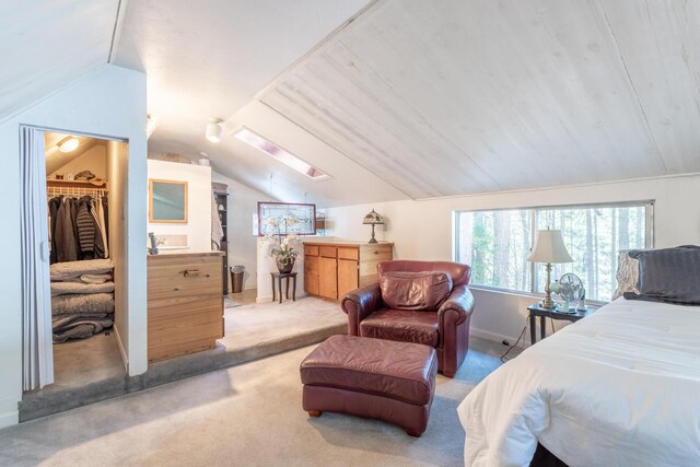 carpeted bedroom with a spacious closet, vaulted ceiling with skylight, a closet, and wooden ceiling