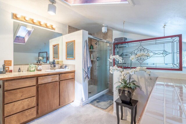 bathroom with lofted ceiling with skylight, vanity, and an enclosed shower