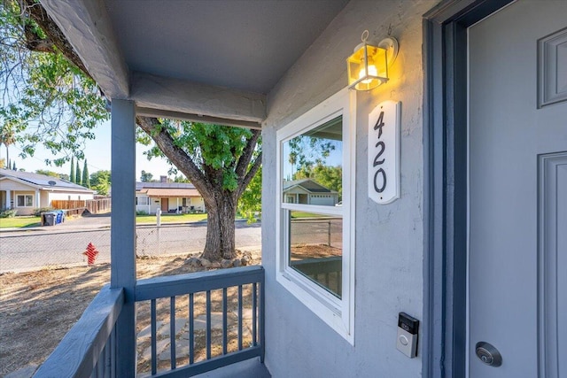 exterior space with covered porch, a residential view, and fence