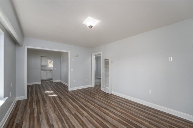 empty room featuring dark wood-style flooring and baseboards