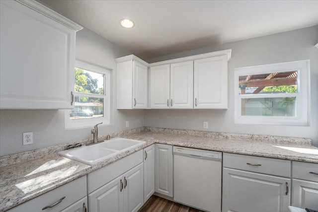 kitchen with a sink, white cabinetry, light countertops, dishwasher, and dark wood finished floors