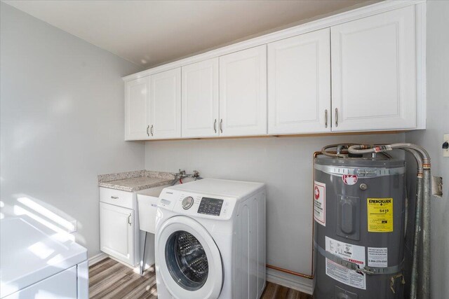 washroom with washer / clothes dryer, cabinet space, wood finished floors, and electric water heater