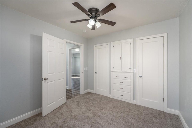 unfurnished bedroom with carpet flooring, a ceiling fan, and baseboards