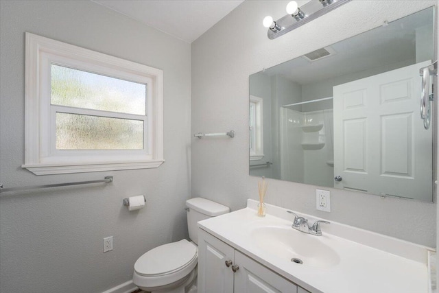 full bathroom featuring toilet, visible vents, walk in shower, and vanity