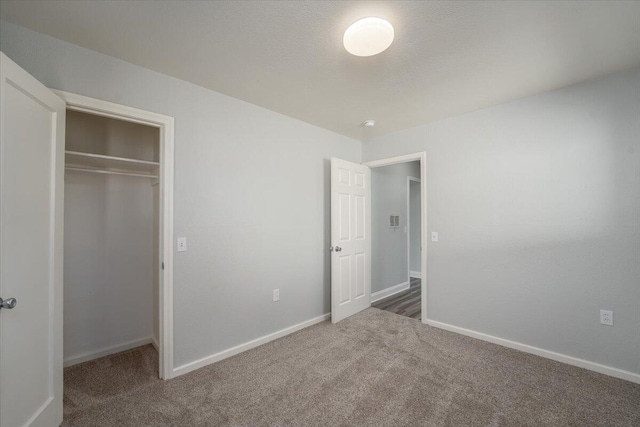 unfurnished bedroom featuring carpet floors, a closet, and baseboards