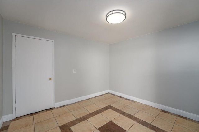 spare room featuring baseboards and tile patterned floors