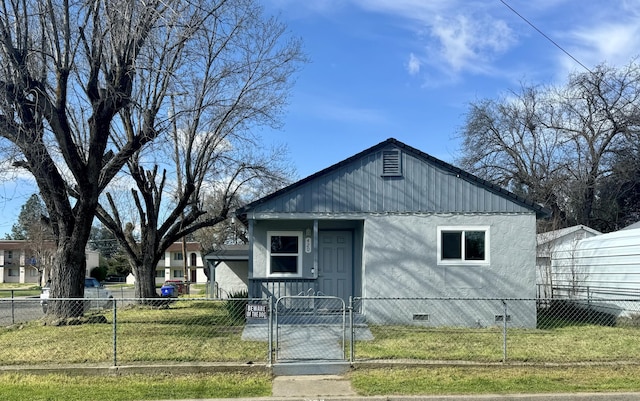 view of front of house featuring a front lawn, crawl space, a fenced front yard, and a gate