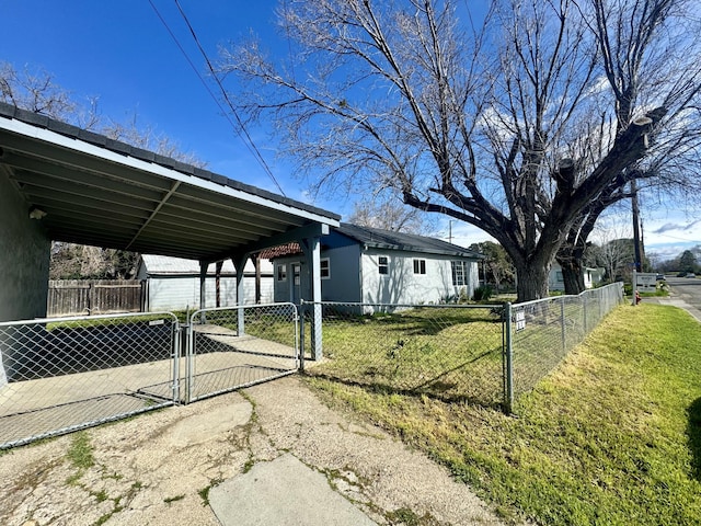 exterior space featuring fence private yard, a gate, a yard, and an outbuilding