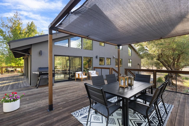 wooden terrace featuring outdoor dining space and area for grilling