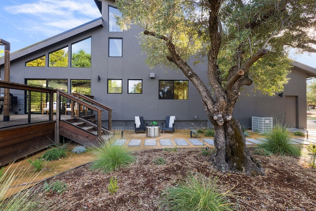 back of property with a deck, central AC, and a patio area