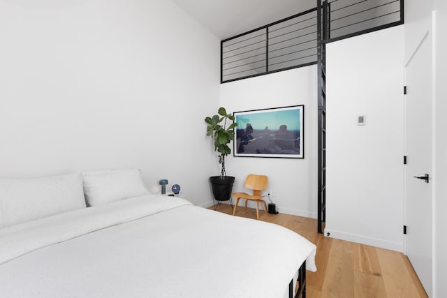 bedroom with light wood finished floors and baseboards