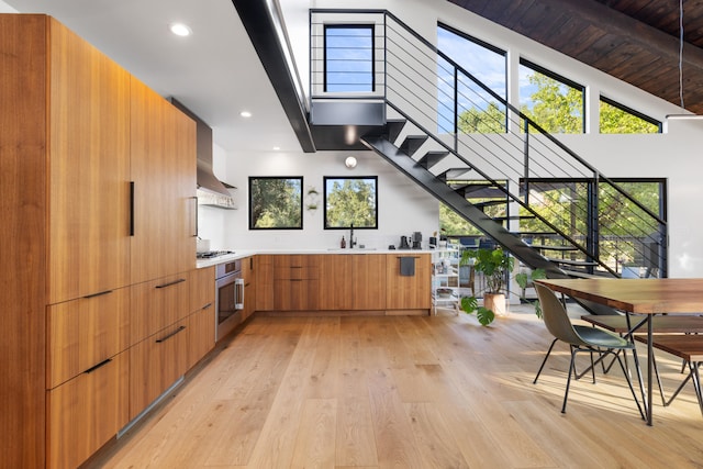 kitchen featuring gas cooktop, oven, light wood-style floors, light countertops, and modern cabinets