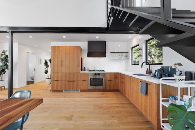 kitchen featuring modern cabinets, stainless steel appliances, open shelves, a sink, and exhaust hood