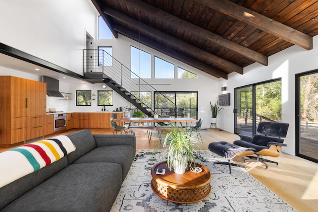 living room with wood ceiling, stairway, beamed ceiling, light wood-style floors, and high vaulted ceiling