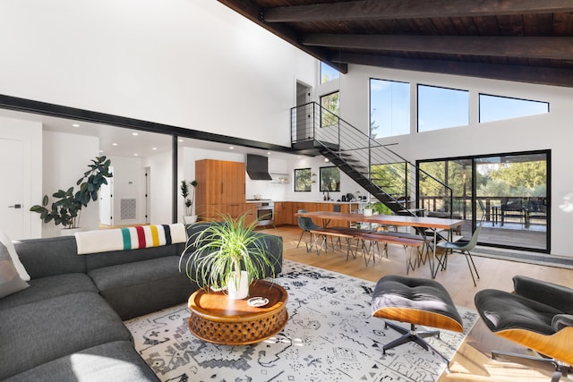 living room with high vaulted ceiling, wooden ceiling, stairway, and beam ceiling