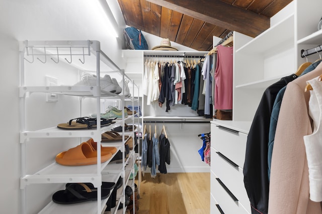 spacious closet featuring vaulted ceiling with beams and light wood finished floors