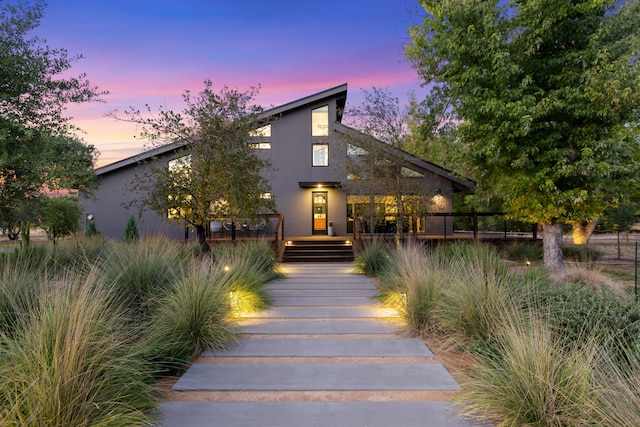 view of front of house featuring a deck and stucco siding