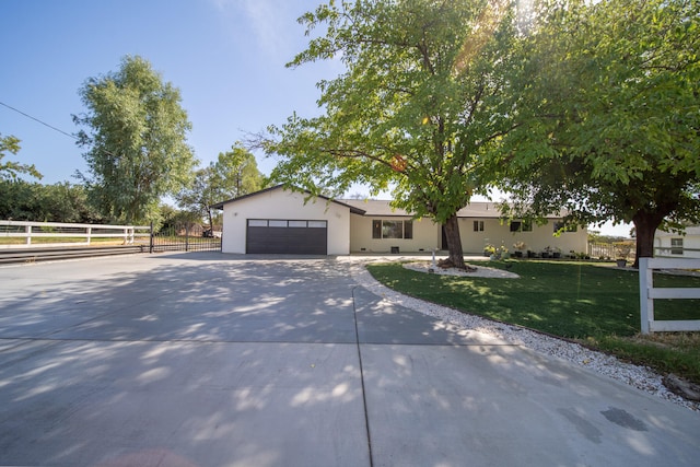 ranch-style home featuring a garage and a front lawn