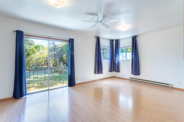 unfurnished room with a baseboard heating unit, ceiling fan, and light wood-type flooring